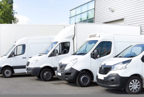 Varios coches furgonetas camiones estacionados en el estacionamiento para alquiler o entrega